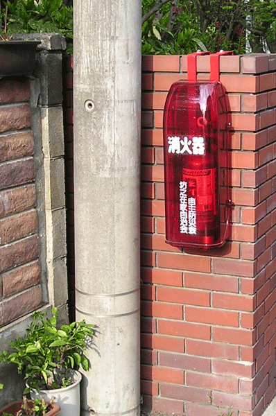 街頭消火器　掲示板のポールに取付けたところです。　ブロックにつり下げ金具で取付けたところです。